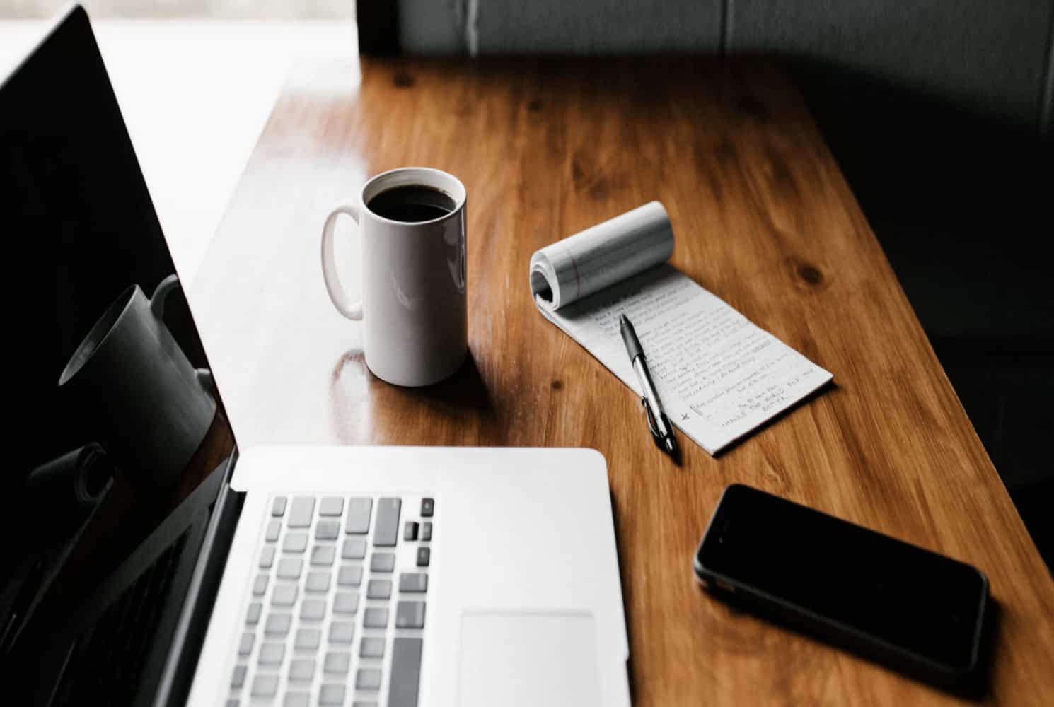Cup Of Coffee, Notepad and Pen, and Laptop On A Table