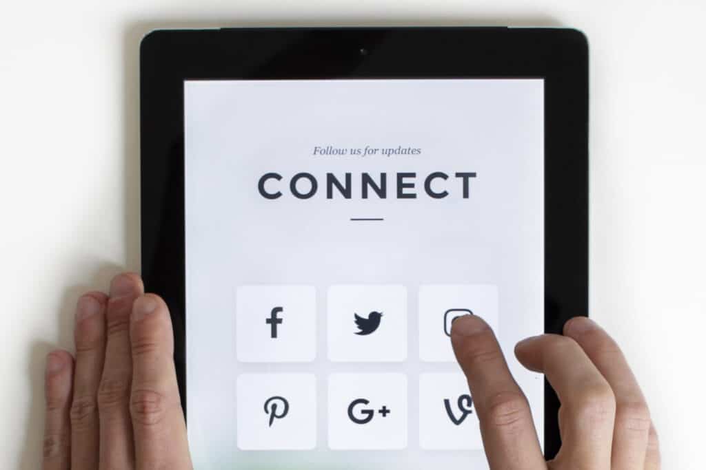 Person Using Tablet With Social Media Icons