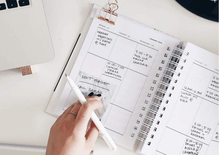 Person using a calendar planner notebook