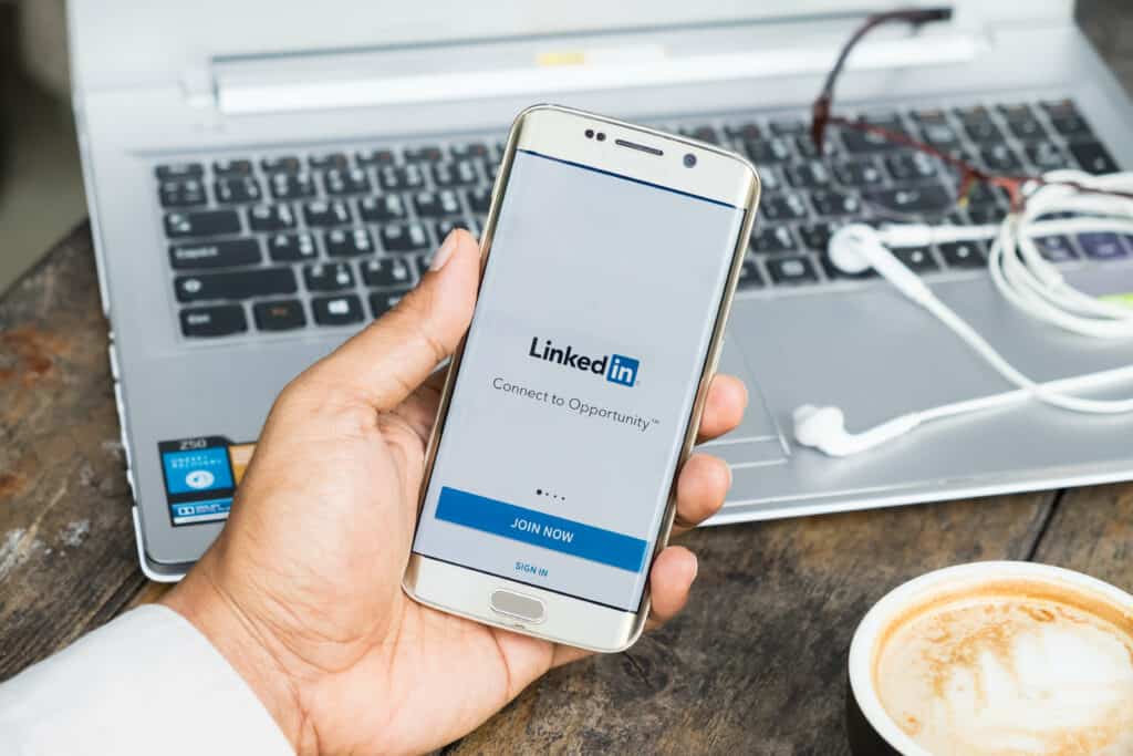 Person holding cellphone showing LinkedIn page