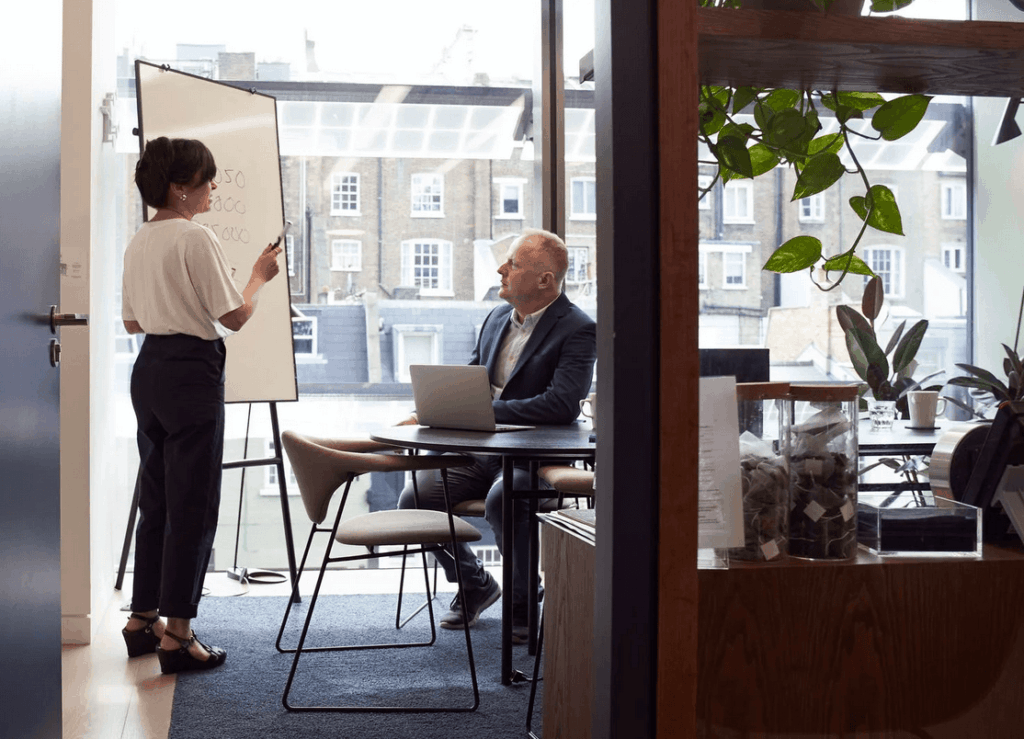 Woman presenting business presentation to man in office