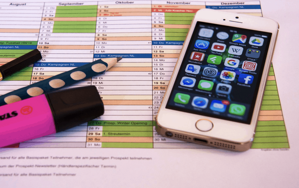 Yearly calendar print out on table with cellphone and pens