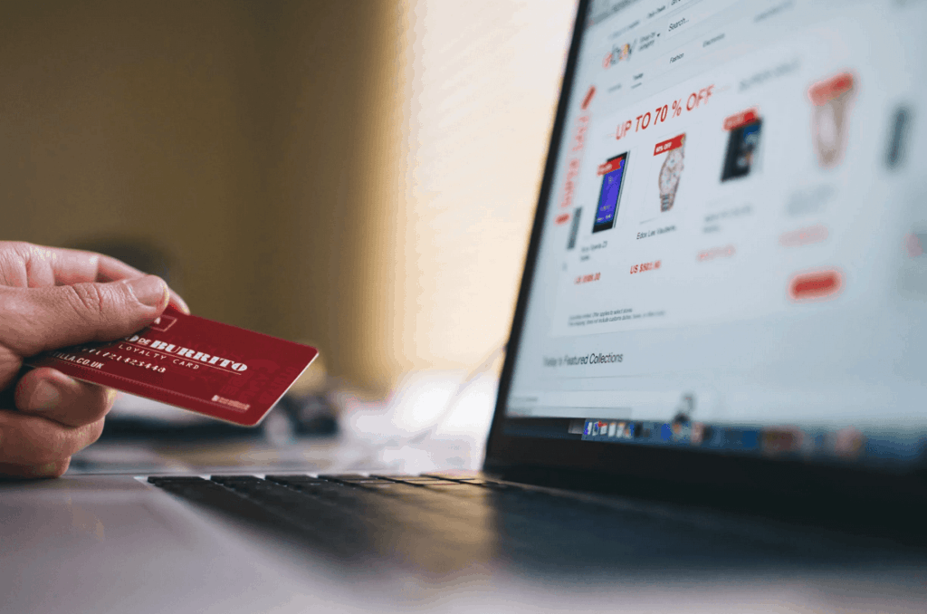 Person using laptop to make ecommerce purchase with credit card