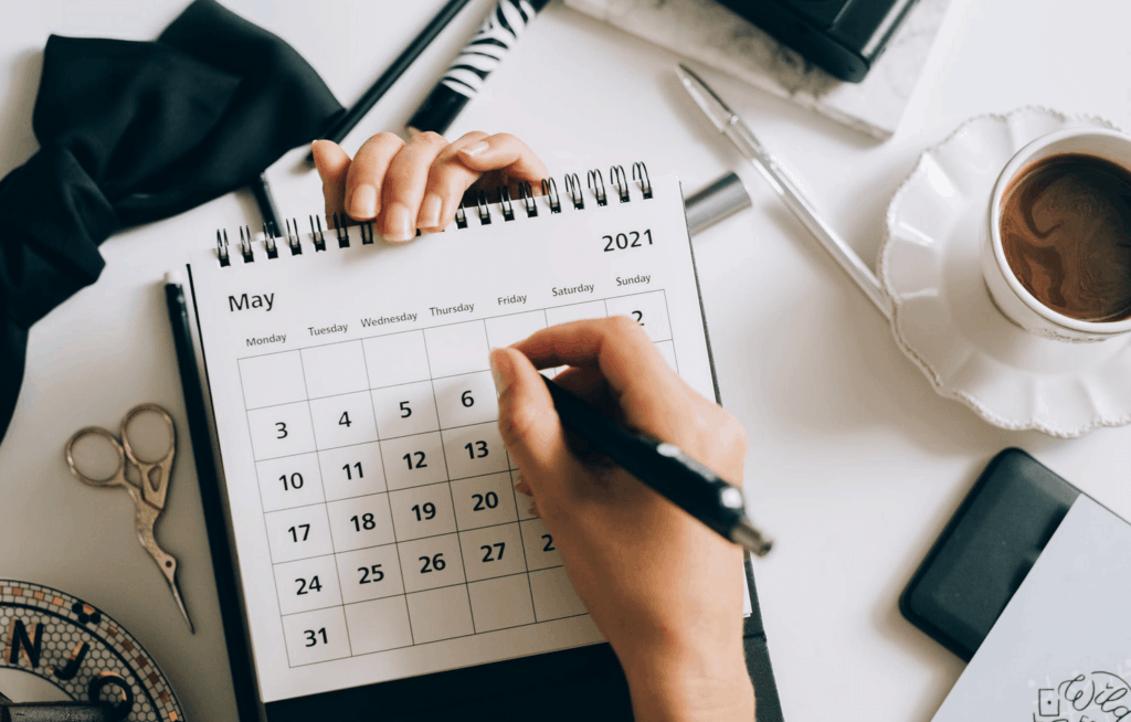 Person writing on May 2021 calendar