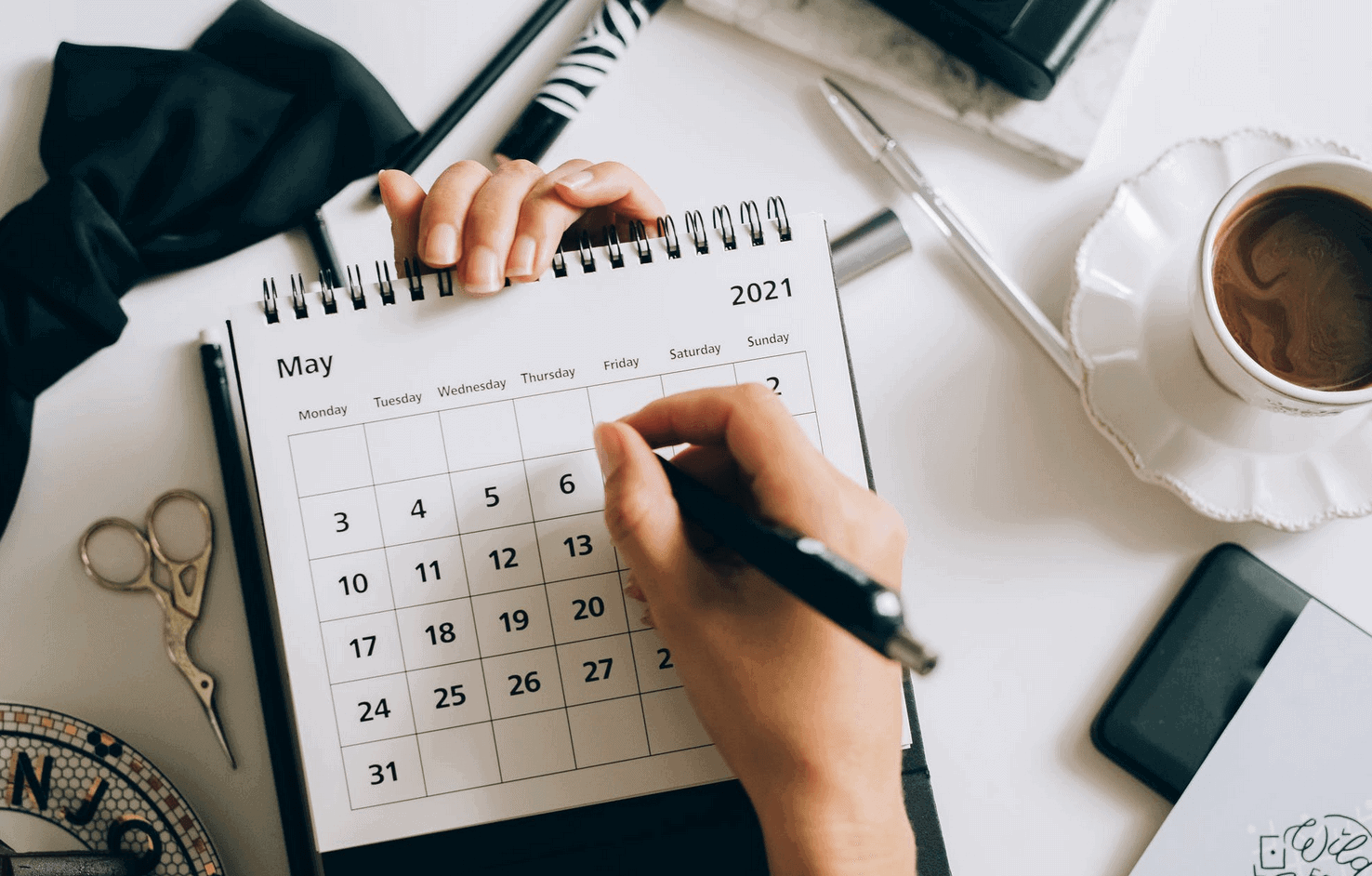 Person writing on May 2021 calendar