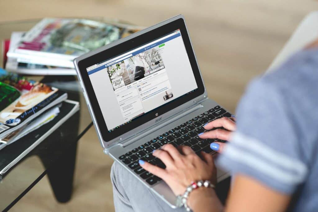 Woman using laptop to update Facebook business page
