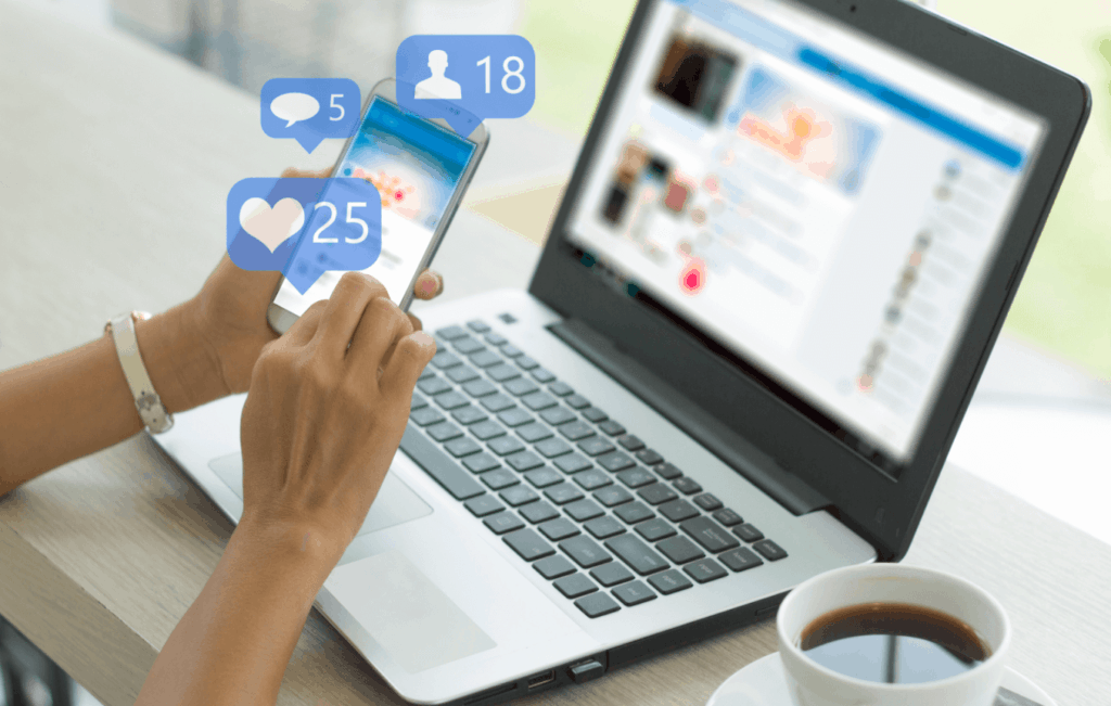Person using phone and laptop to view social media