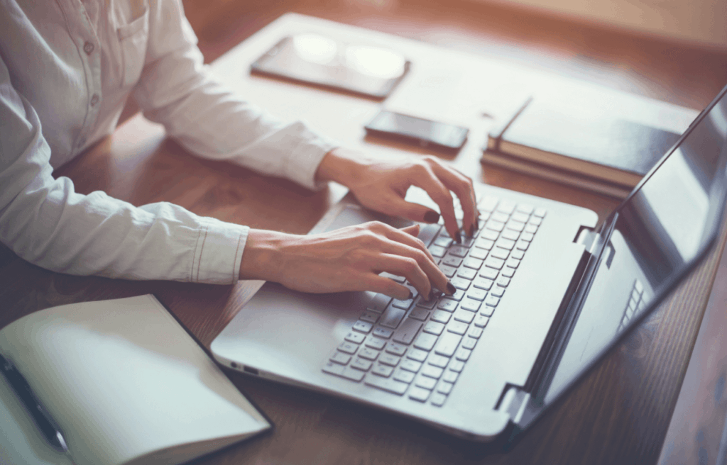 Person sitting at desk typing on a laptop